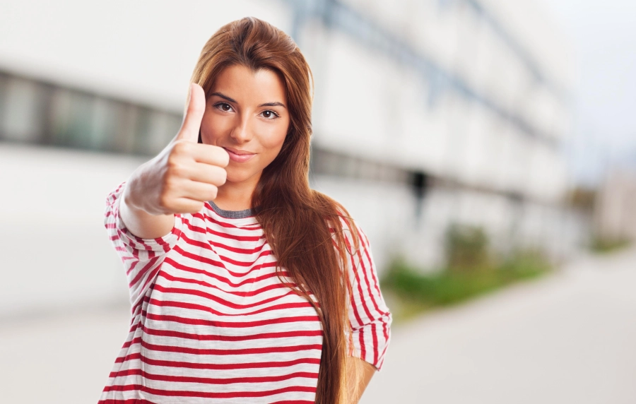 une femme montre le pouce en l'air qui veut dire "top""