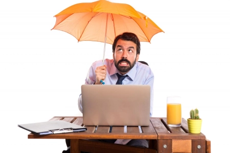 Homme d'affaires dans son bureau tenant un parapluie
