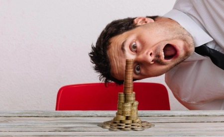 Investisseur surpris devant une pile de pièces illustrant les opportunités et les risques de l’investissement digital